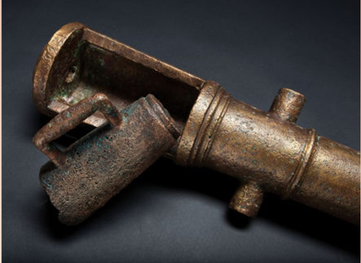 Detail of the loading end of a French bronze cannon with a large copper alloy stein-shaped tool to help load the cannon.